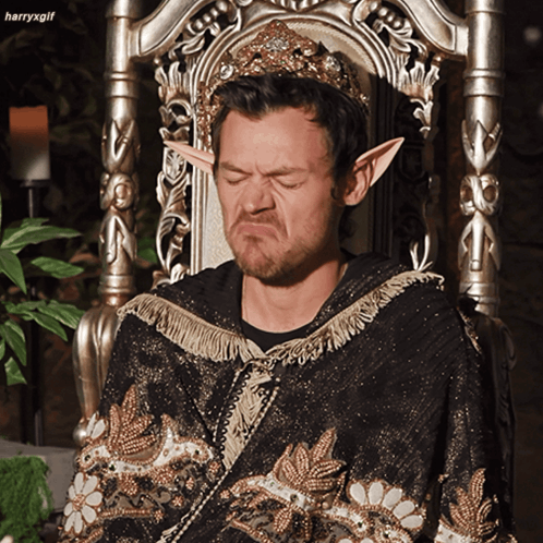 Man in Crown and Elf Ears Sitting on Chair