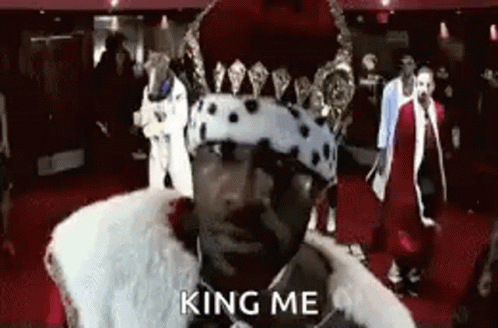 Man in Crown and Fur Coat Saying King Me on Red Carpet