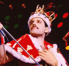 Man in Crown and Red Robe Holding Microphone