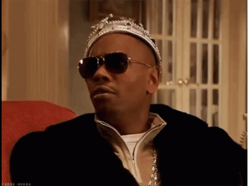 Man in Crown and Sunglasses Sitting