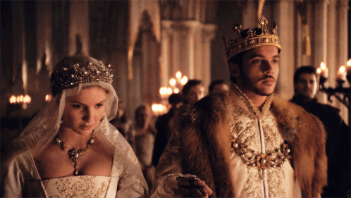 Man in Crown Next to Woman in Wedding Dress
