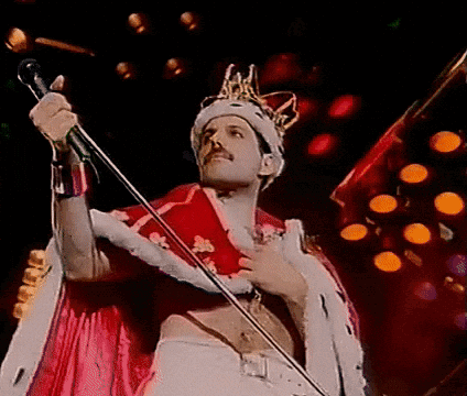 Man in Crown Singing Into Microphone