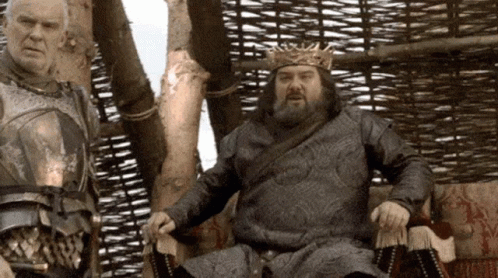 Man In Crown Sitting Next To Another Man GIF