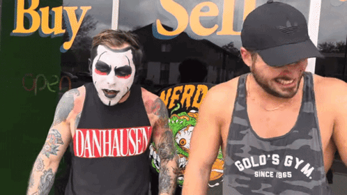Man in Danhausen Shirt Next to Man in Gold S Gym Shirt