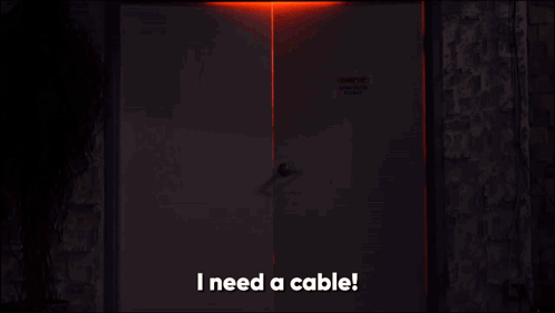 Man in Dark Room Saying I Need a Cable