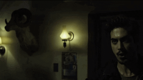 Man In Dark Room With Glowing Eyes GIF