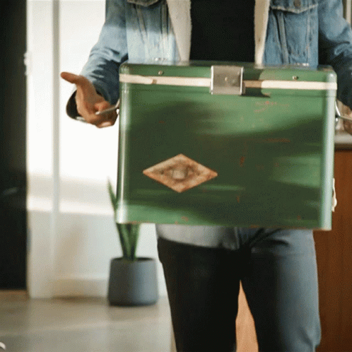 Man in Denim Jacket Holding Green Cooler With Diamond
