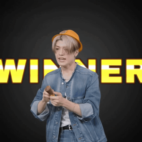 Man in Denim Jacket Holding Wood at Winner Sign
