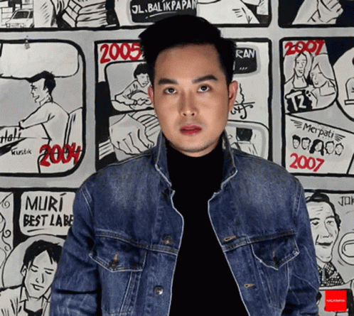 Man in Denim Jacket Near 2007 Comic Strip Wall