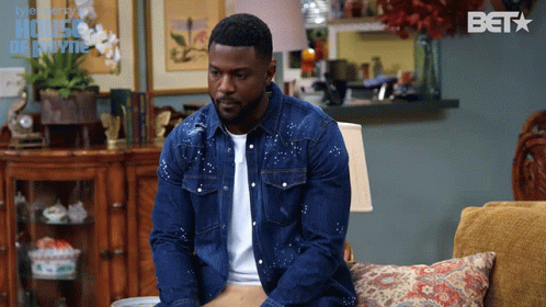 Man in Denim Jacket on Couch With BET Logo