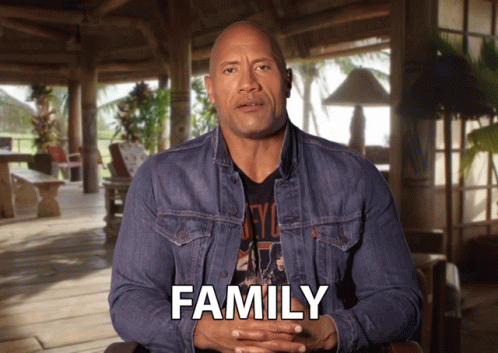 Man in Denim Jacket Sitting in Front of Family Screen