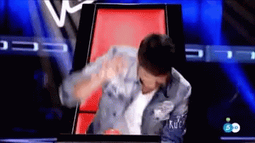 Man in Denim Jacket Sitting on Red Chair on TV Show