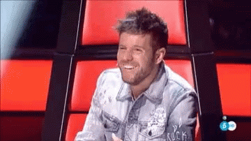Man in Denim Jacket Smiling in Red Chair