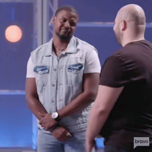 Man In Denim Vest Talking To Man In Black Shirt On Bravo GIF
