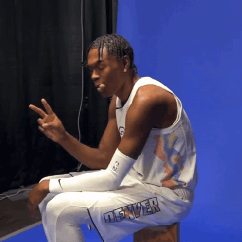 Man in Denver Jersey Sitting on Stool