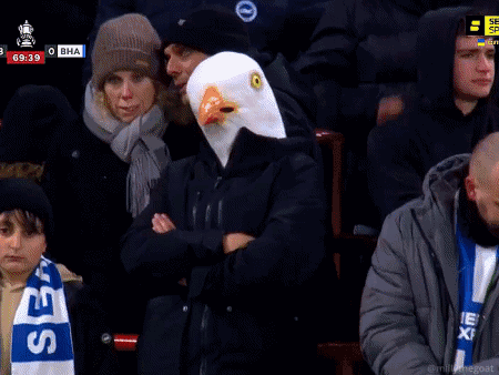 Man in Eagle Mask Giving Peace Sign in Crowd
