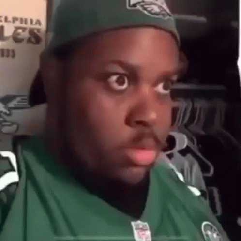 Man in Eagles Jersey and Hat Making Funny Face