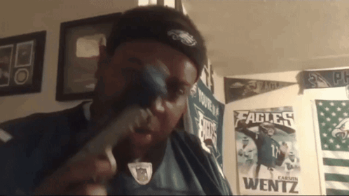 Man In Eagles Shirt Holding Hammer GIF