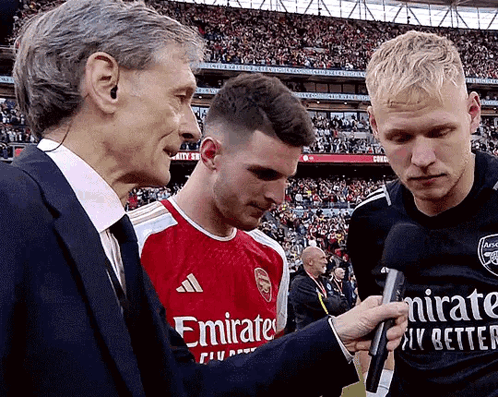 Man In Emirates Shirt Interviewed By Two Men GIF