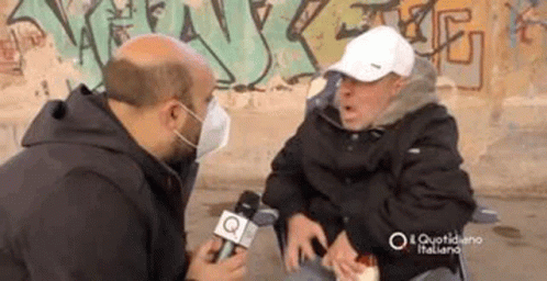 Man in Face Mask Talking to Man in Wheelchair