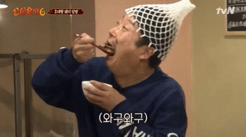 Man in Fishnet Hat Eating Food With TVN Sign