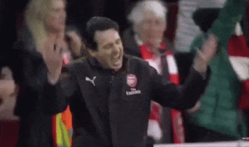 Man in Fly Emirates Jacket Standing in Front of Crowd