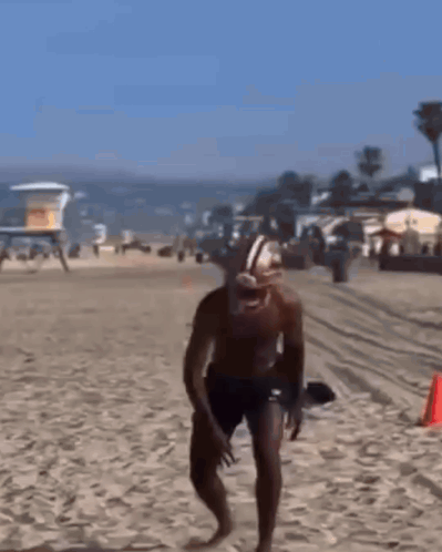 Man in Football Helmet and Shorts Running on Beach