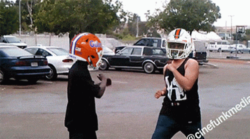 Man in Football Helmet Next to Man in Tank Top With Letter K