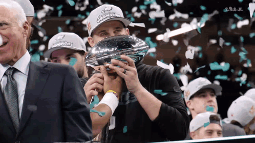 Man In Ford Champions Hat Holding Trophy In Mouth GIF