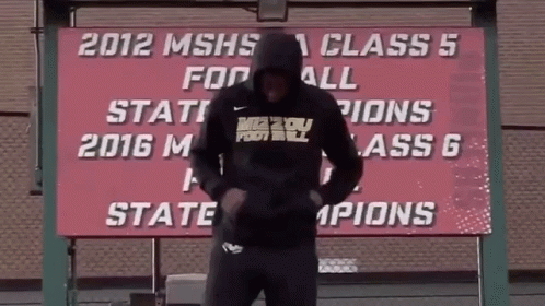 Man in Front of 2012 MSHS Class 5 Football State Champions Sign