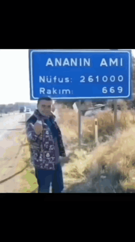 Man in Front of Blue Sign Saying Ananin Ami