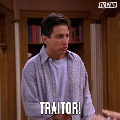 Man in Front of Bookshelf Says Traitor