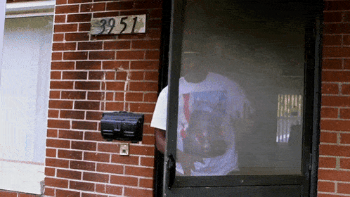 Man in Front of Brick Building With Sign 39 51