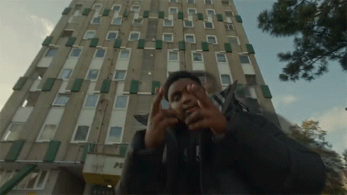 Man In Front Of Building With Peace GIF