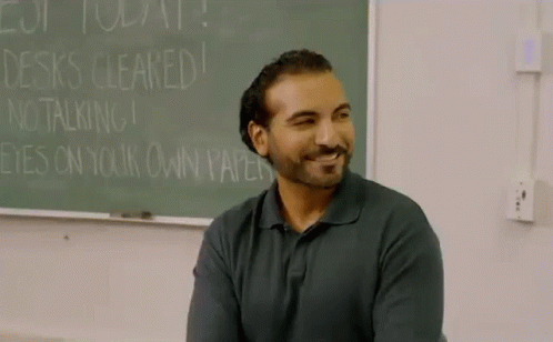 Man in Front of Chalkboard Saying Desks Cleared