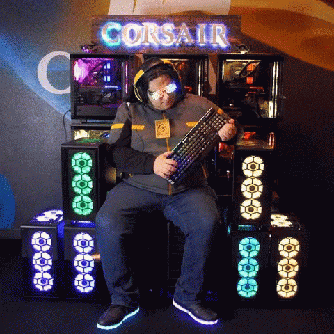 Man in Front of Corsair Sign Holding Keyboard