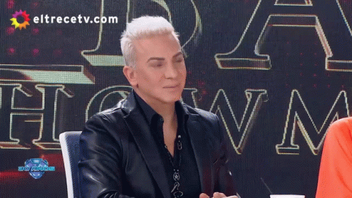 Man In Front Of Eltrecetv.com Sign GIF