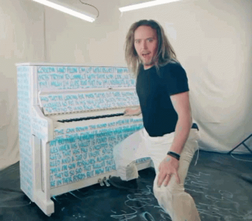 Man In Front Of Piano Covered In Writing GIF