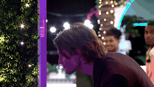 Man In Front Of Purple Light Looking Down GIF