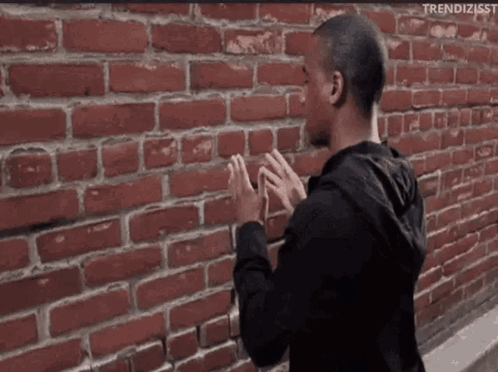 Man in Front of Red Brick Wall