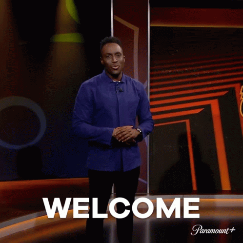 Man in Front of Screen Saying Welcome