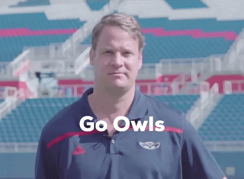 Man in Front of Stadium Saying Go Owls
