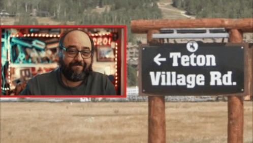 Man in Front of Teton Village Road Sign