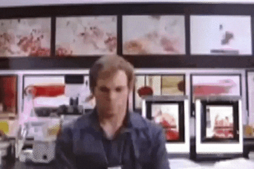 Man In Front Of Wall With Pictures GIF