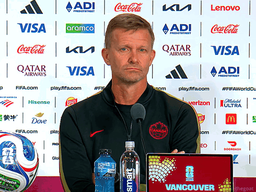 Man In Front Of Wall With Qatar Airways And Visa Sponsors GIF