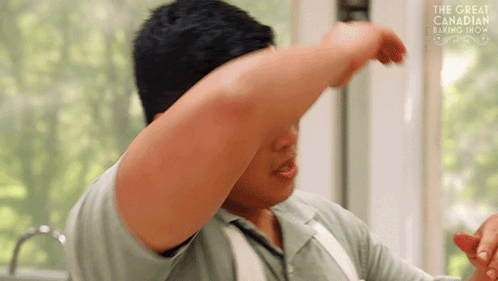 Man in Front of Window With Arm Outstretched and The Great Canadian Baking Show Sign