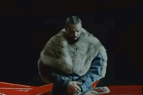 Man in Fur Coat Sitting on Red Car