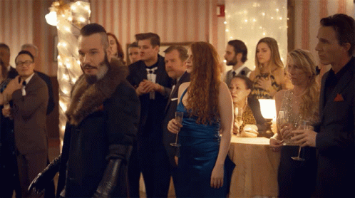Man In Fur Coat Standing In Crowd GIF