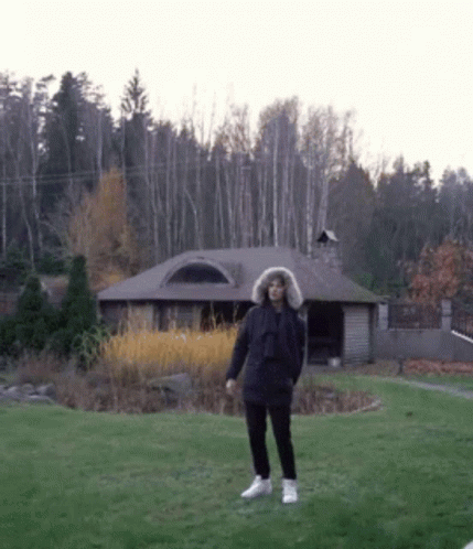 Man In Fur Hooded Jacket In Front Of House GIF