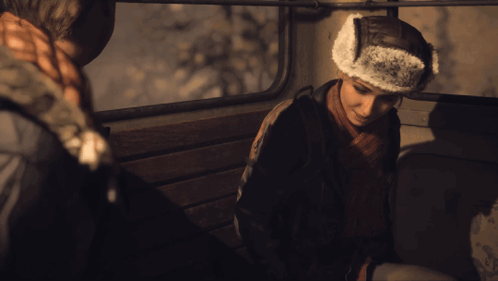 Man In Furry Hat Sitting In Dark Room GIF